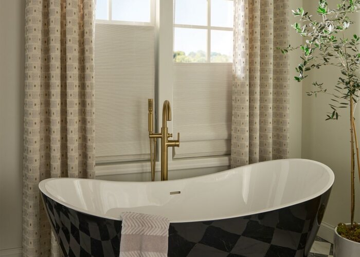 woven wood shades Austin TX bathroom installation with layered drapery and freestanding tub