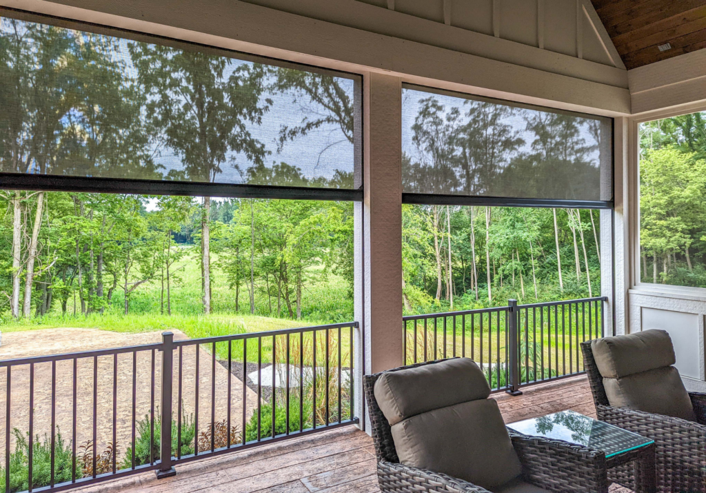 Motorized exterior solar shades installed on a covered patio in Austin, TX, providing shade, privacy, and glare reduction while maintaining open backyard views.