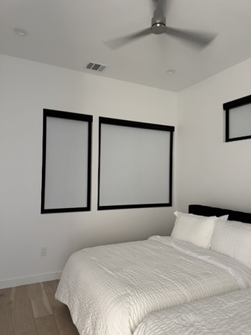 Motorized roller shades with Norman Light Guard side channels installed in a Zilker bedroom for enhanced light control and a clean, modern look.