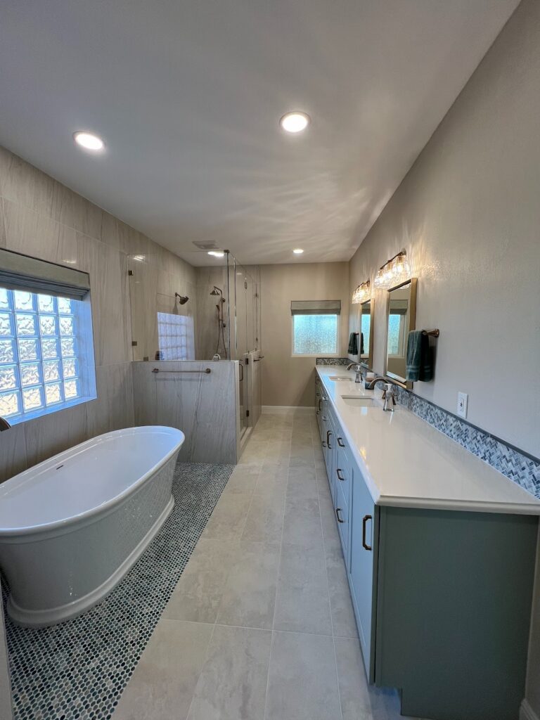 Georgetown bathroom with freestanding tub, walk-in shower, double vanity, and tailored Roman shades filtering natural light.