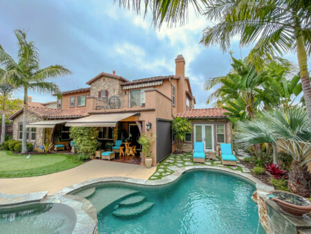 Exterior shades and awnings on a luxury poolside patio with palm trees, lounge chairs, and covered outdoor seating.