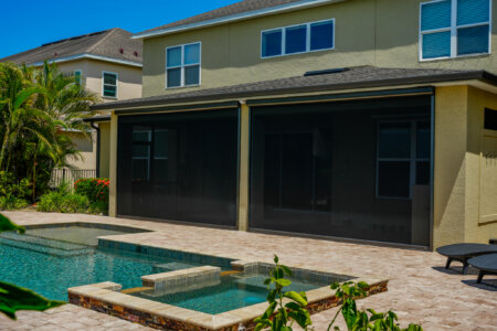 Exterior shades on an Austin poolside patio with stucco exterior, covered outdoor living space, and spa.