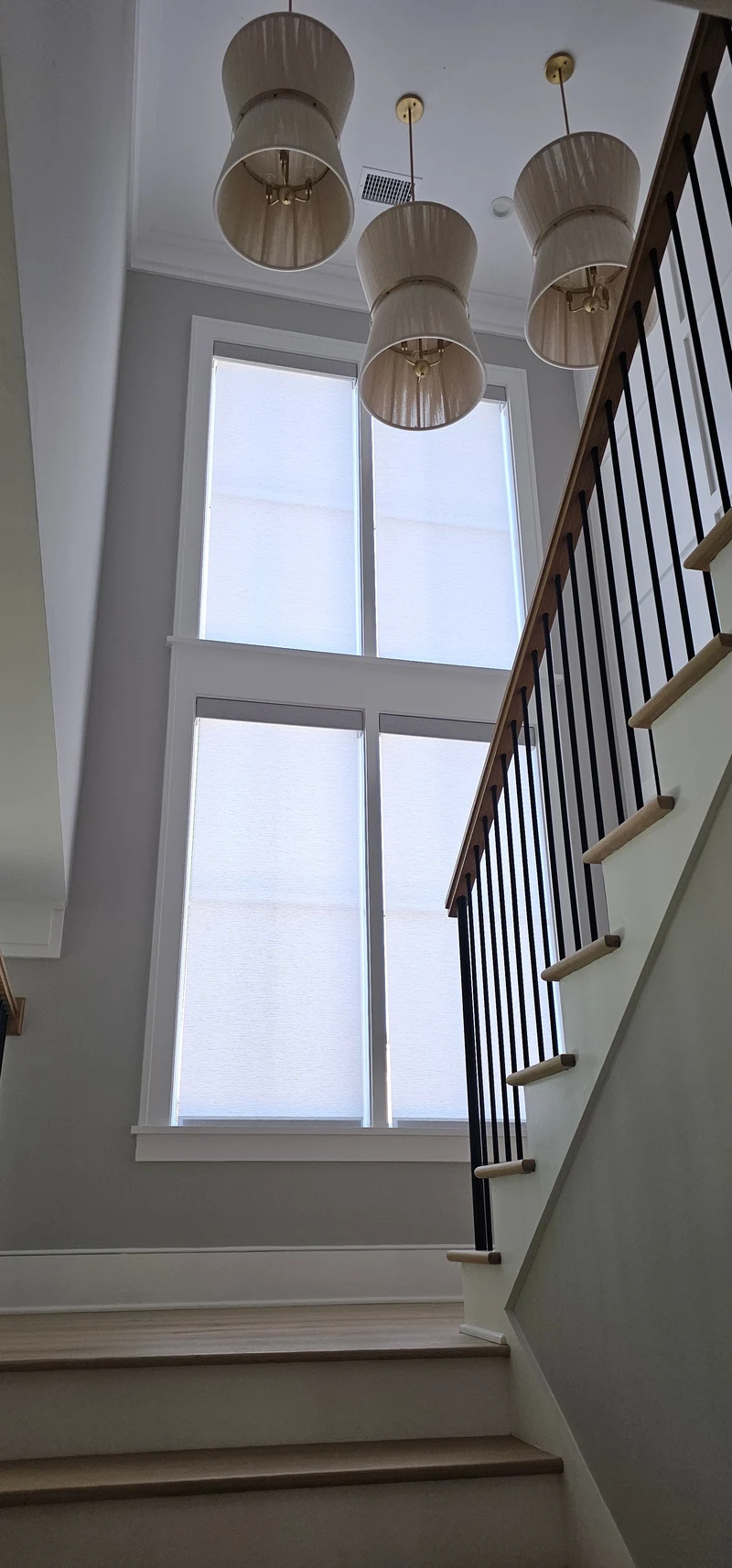 Motorized roller shades installed on stair landing windows