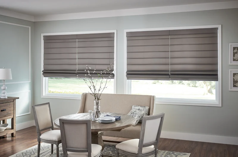 Grey roman shades in dining room windows