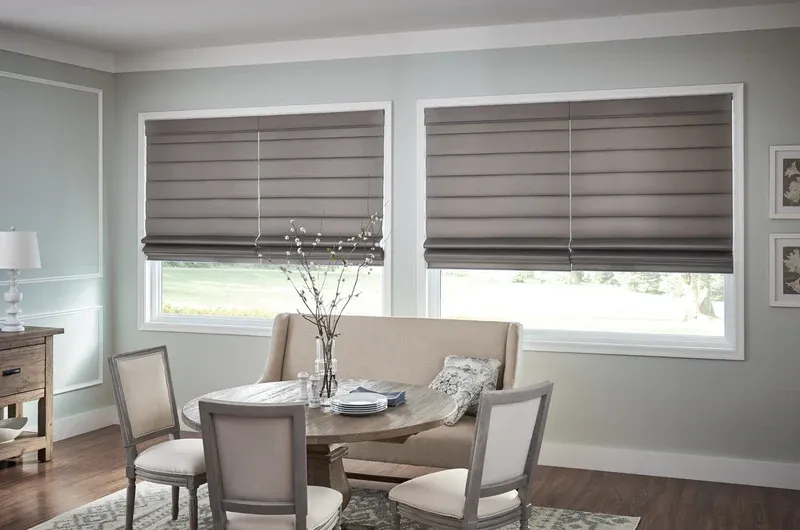 Grey roman shades in dining room windows