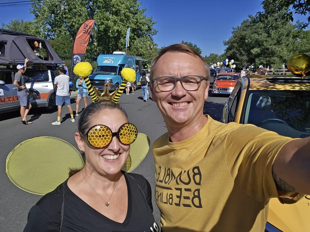 Amber & Eric dressed in Bumble Bee Blinds merch standing in the street