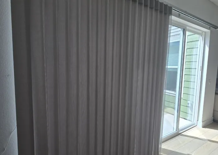 Custom Ripplefold drapery pulled back to reveal a clear mountain view from a modern living room in Boulder.