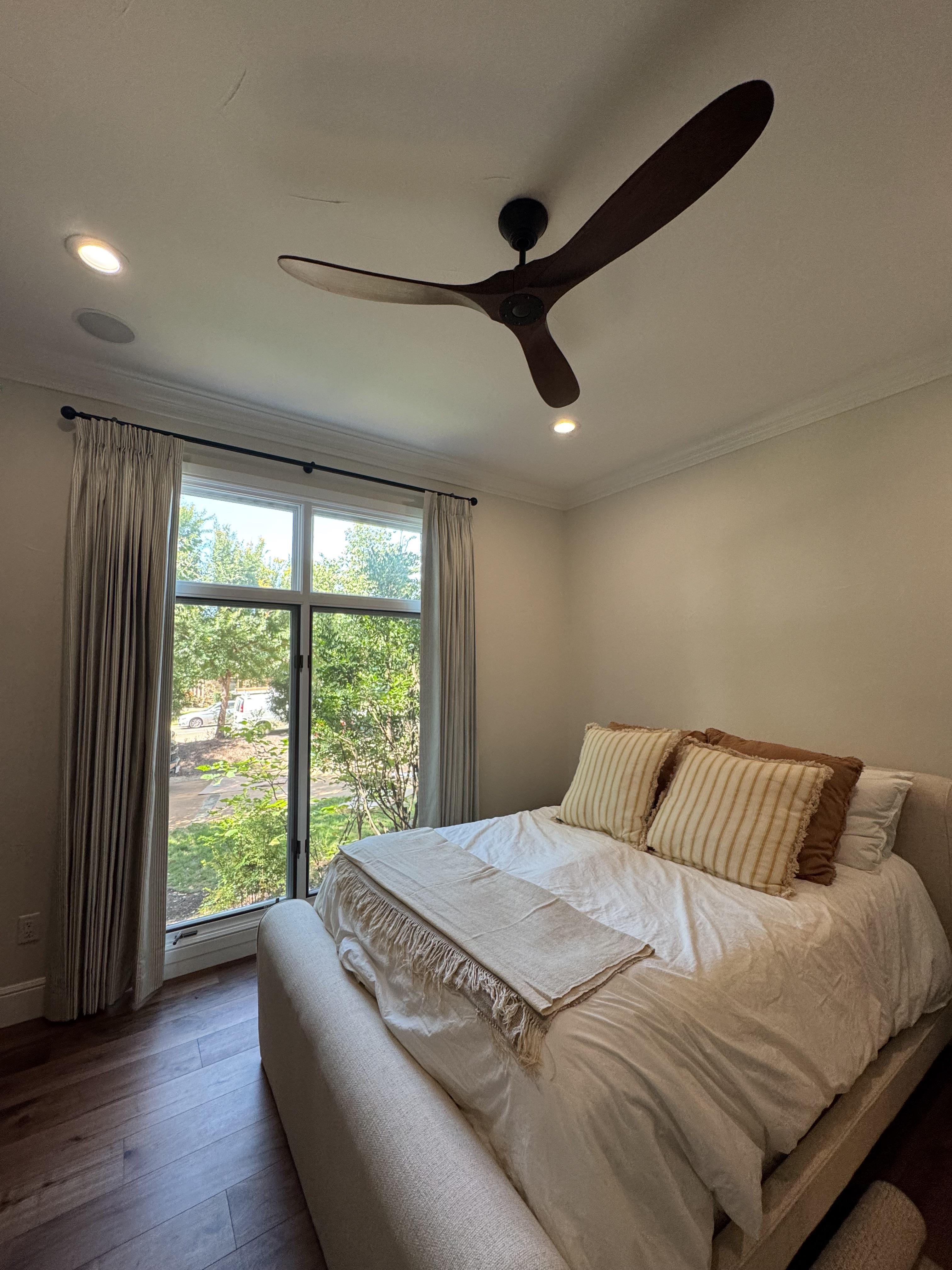 Soft, neutral drapery frames the view and keeps this bedroom feeling light and airy.