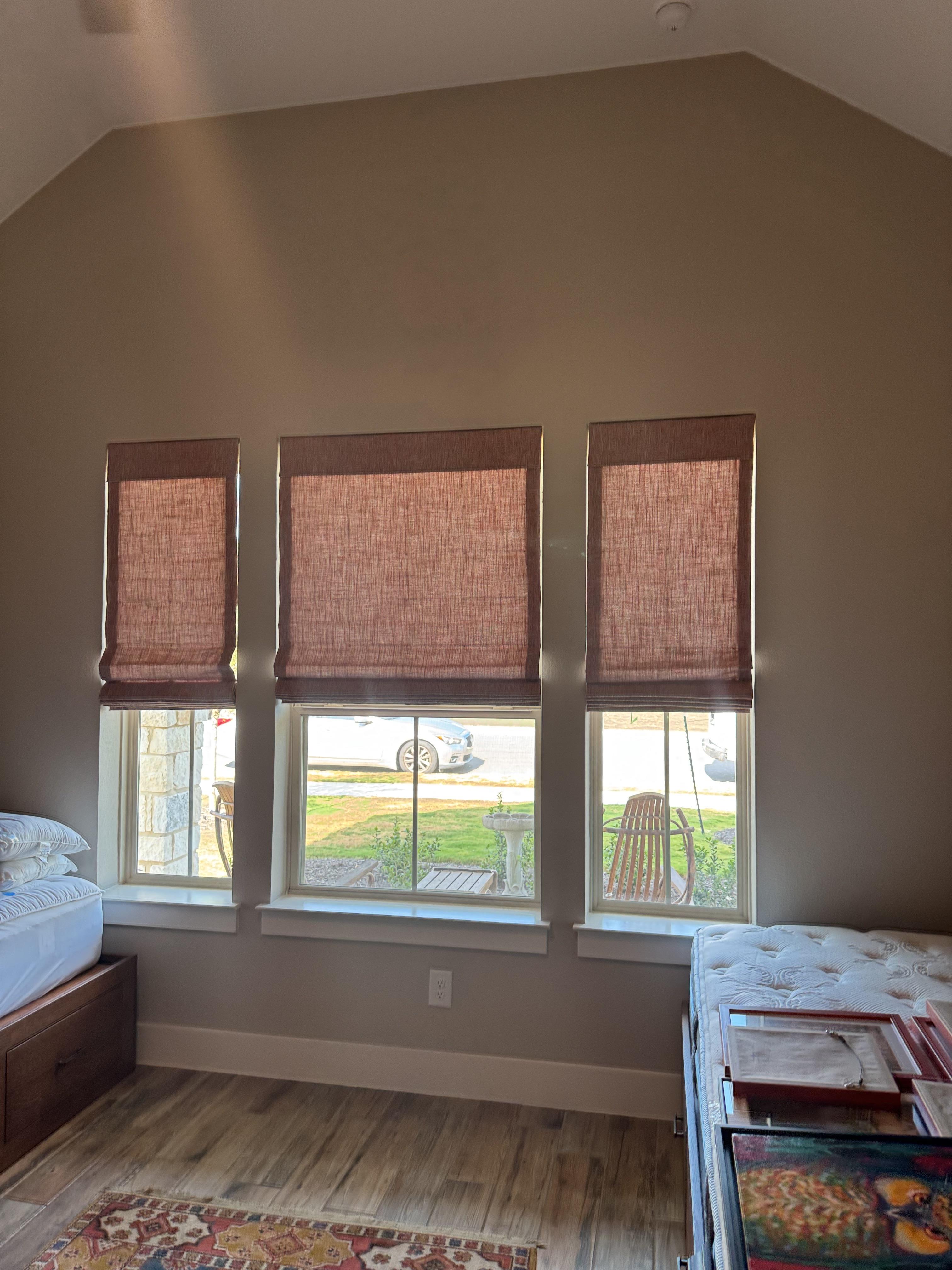 Triple the windows, triple the charm — these Roman shades bring texture and warmth to the guest room.