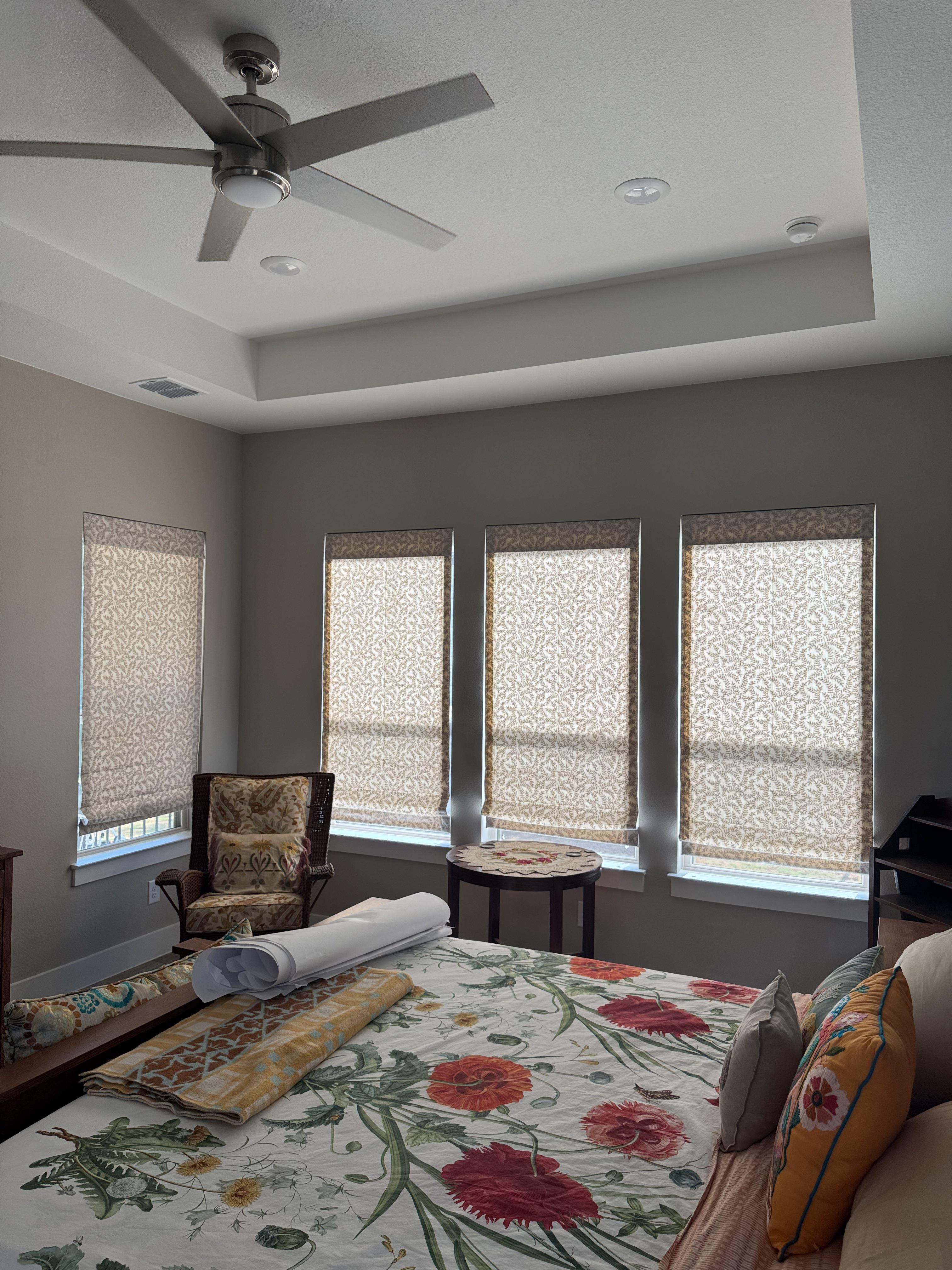 A wall of windows dressed in matching Roman shades for a master suite that’s as stylish as it is private.