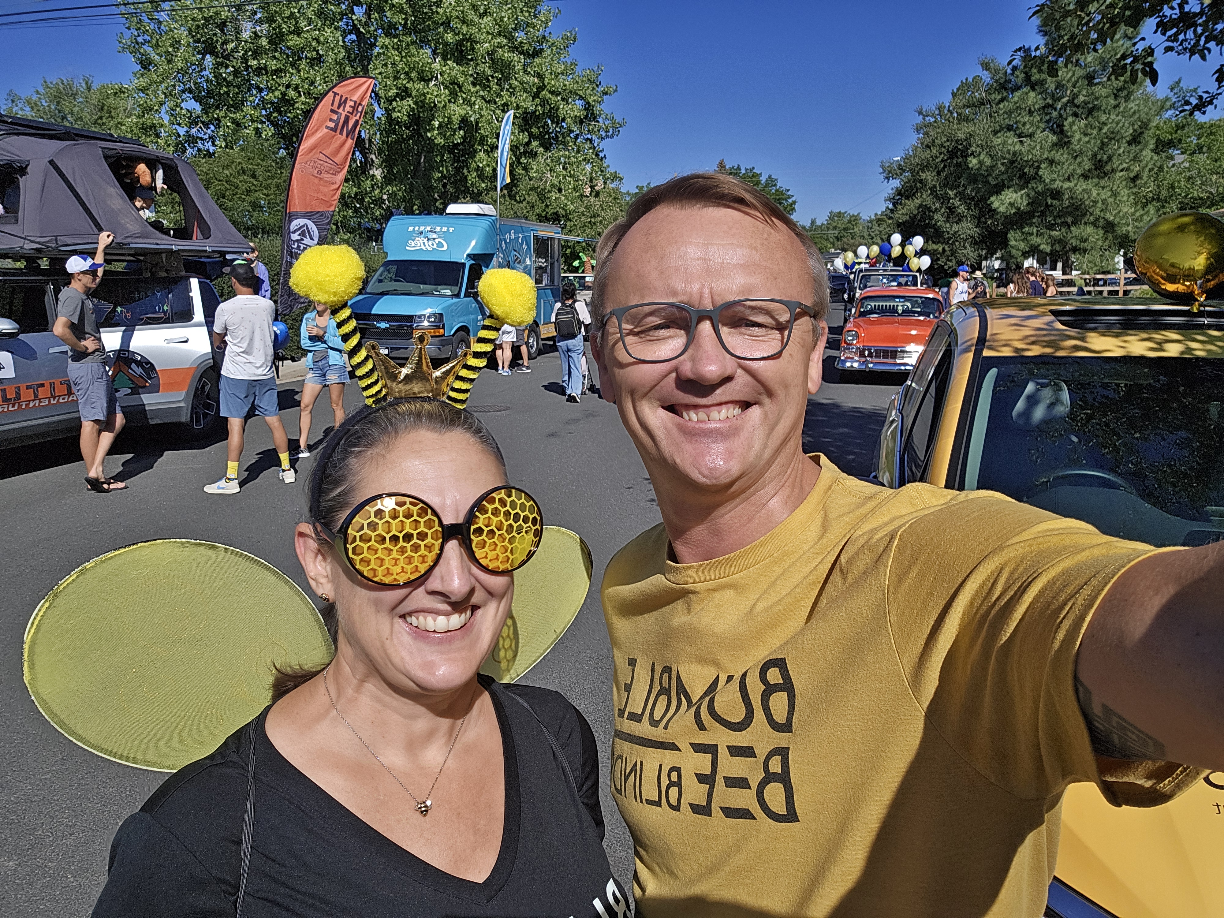 Amber & Eric dressed in Bumble Bee Blinds merch standing in the street